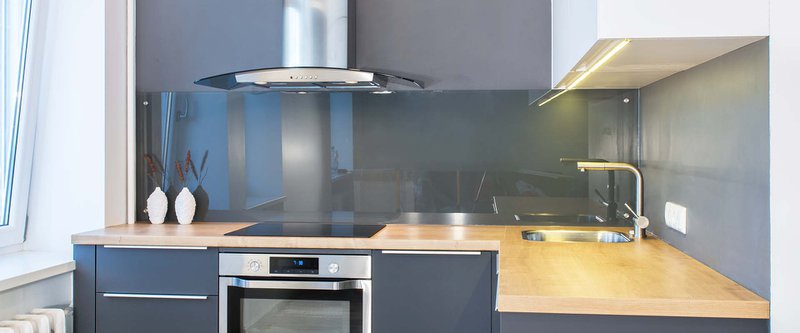 Modern kitchen furniture design in apartment interior with wood accents. Led lights. European, scandinavian style. Painted grey facades. Glass wall panel. Project management. Real estate. Rent. Sale.